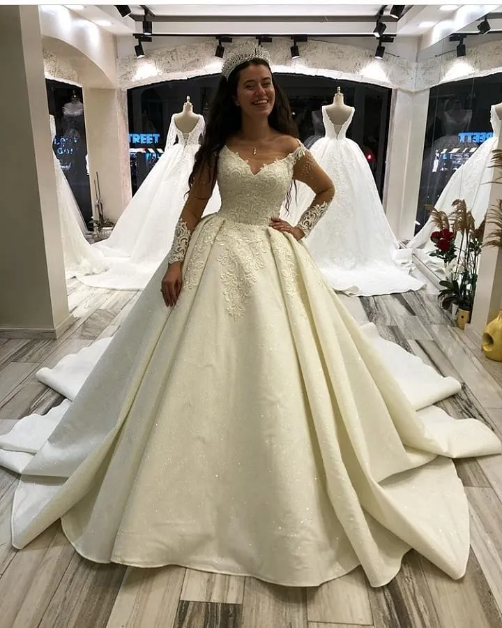 Elegant långärmad prinsessklänning i satin med älskling och applikationer