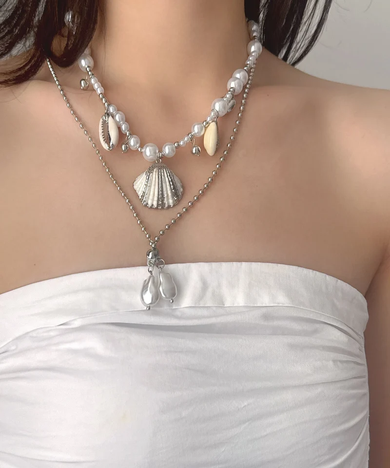 Damhalsband med dubbla lager och snäckskalspärla i modern design