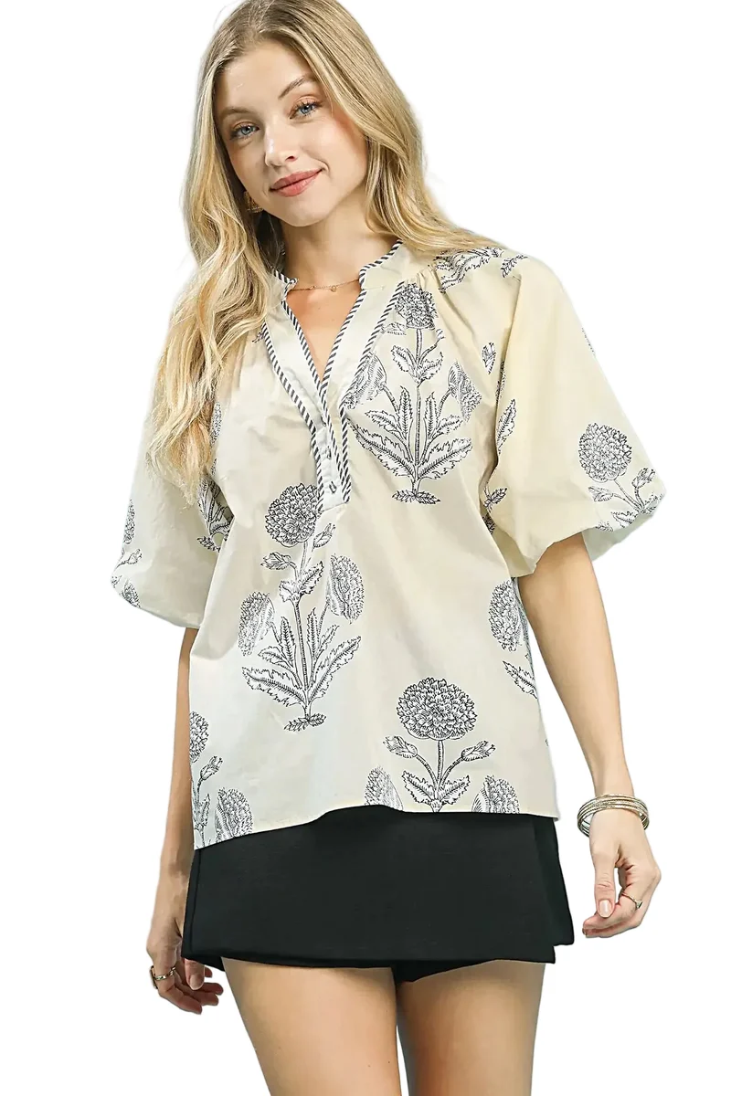 Elegant blommig topp med v-ringning, randiga kanter och puffärmar för en avslappnad och elegant stil